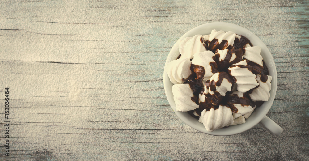Cup of hot chocolate with marshmallows on snowy table, Christmas, New Year, Winter background
