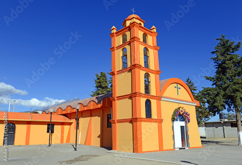 Colorful Church with blue sky background located near borders of Veracruz and Puebla, close to Pico de Orizaba, Iztaccihuatland Popocatepetl volcanoes, Mexico photo