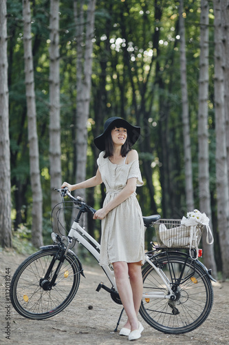 Young woman against nature background with bike