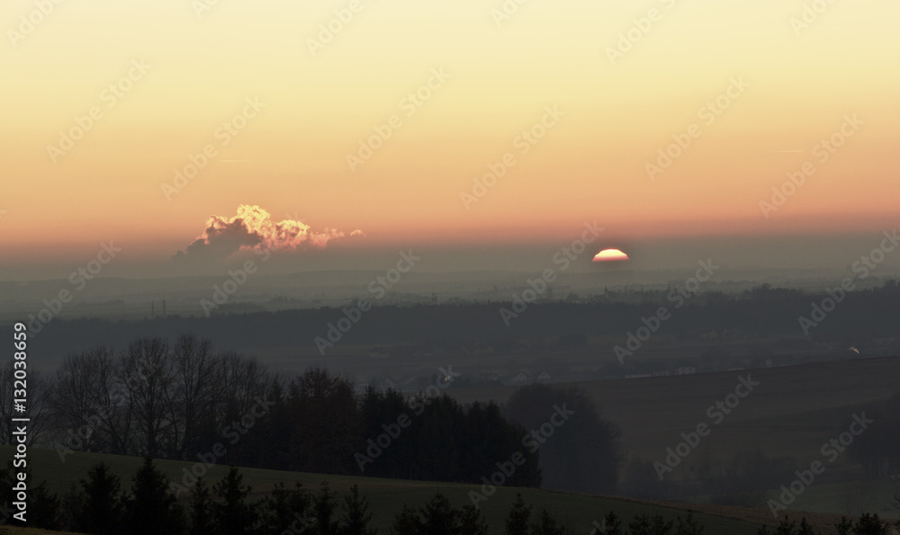 Fototapeta premium Sonnenuntergang über einer weiten Landschaft