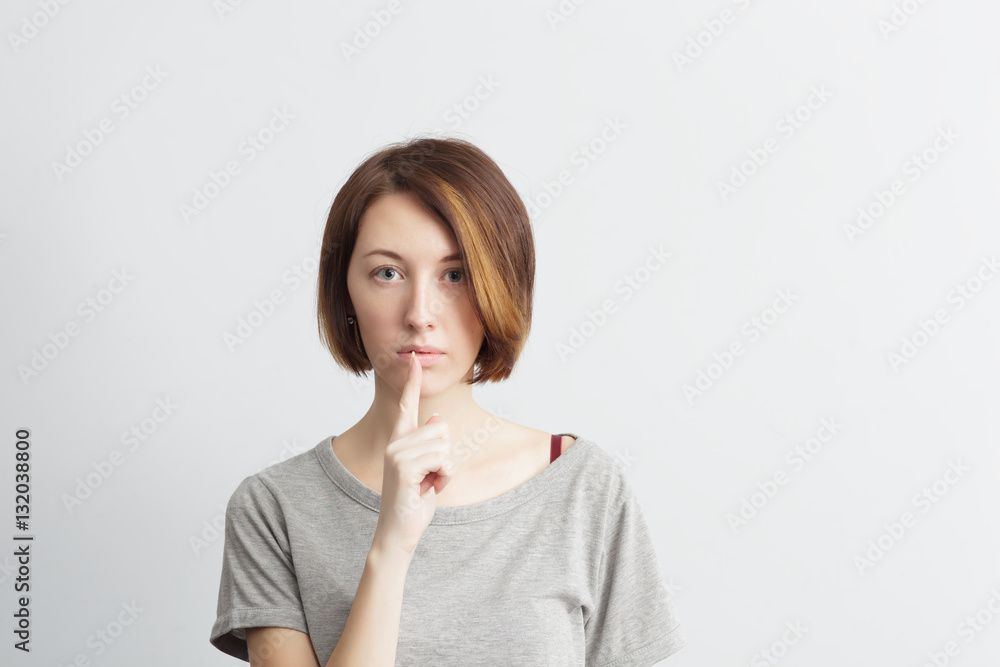 Beautiful, thin girl puts a finger to his lips, a sign of silence Beautiful, thin girl puts a finger to his lips, a sign of silence