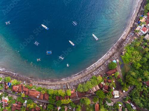 Aerial shot of a calm lagoon with boats and buildings. Bali, Indonesia