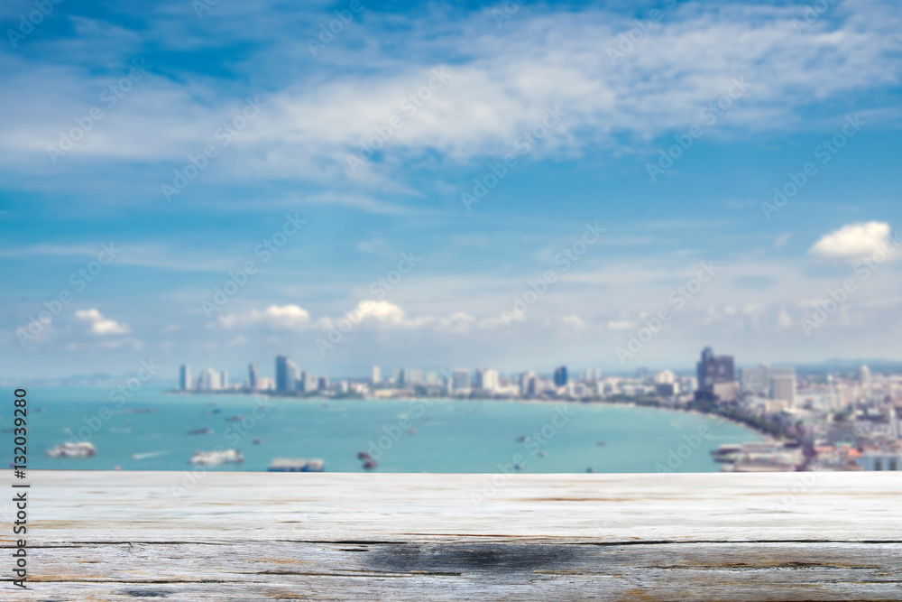 Wood table top on blurred blue sea and pattaya bay background -