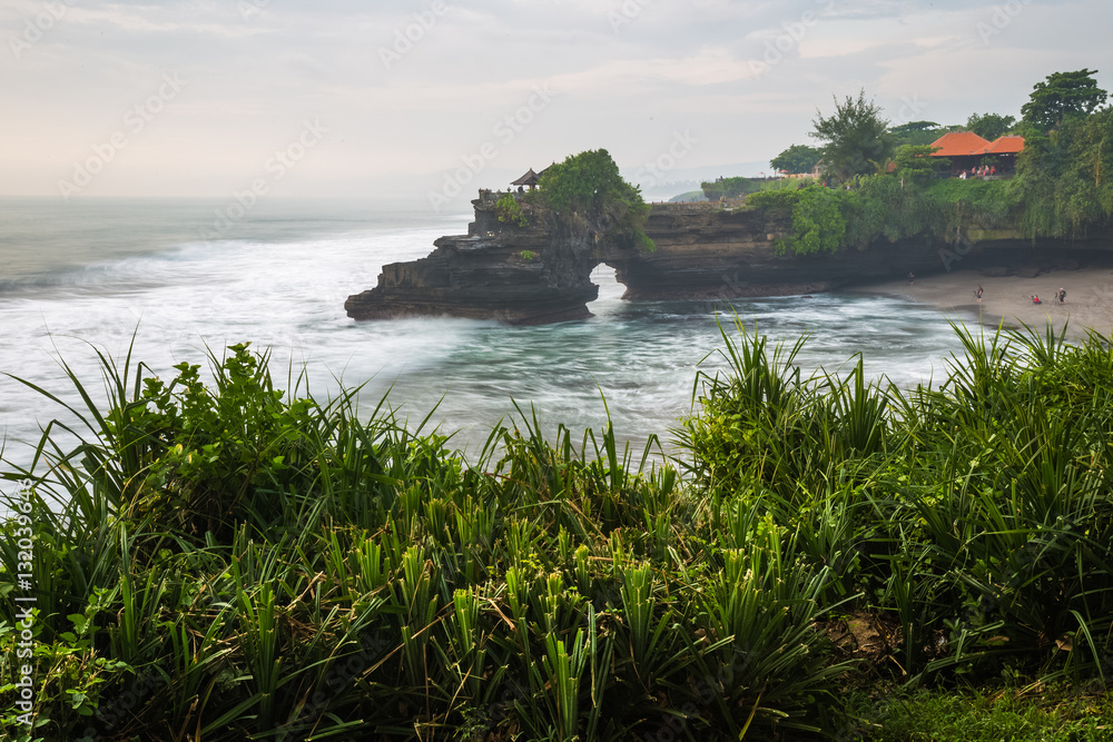 Tanah Lot Temple with green plant on the foreground, Bali, Indonesia Tanah Lot Temple with green plant on the foreground, Bali, Indonesia