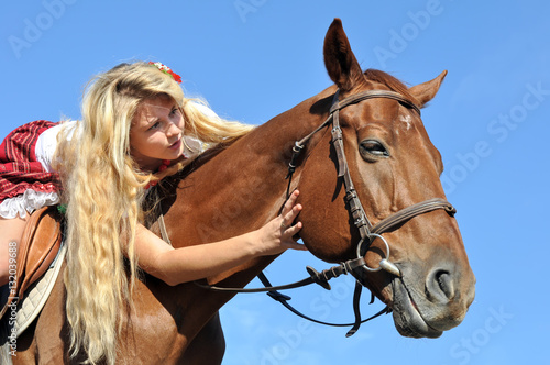 teenage  girl with long hair horseback riding in sunny day © beerfan
