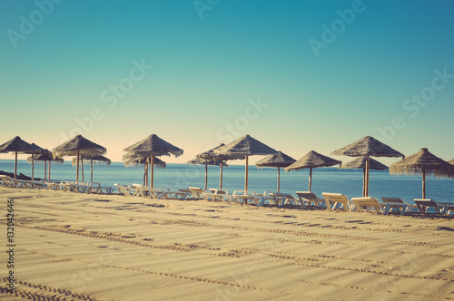 Holiday and vocation image with sandy beach, parasol and chairs on outdoors background © aquar