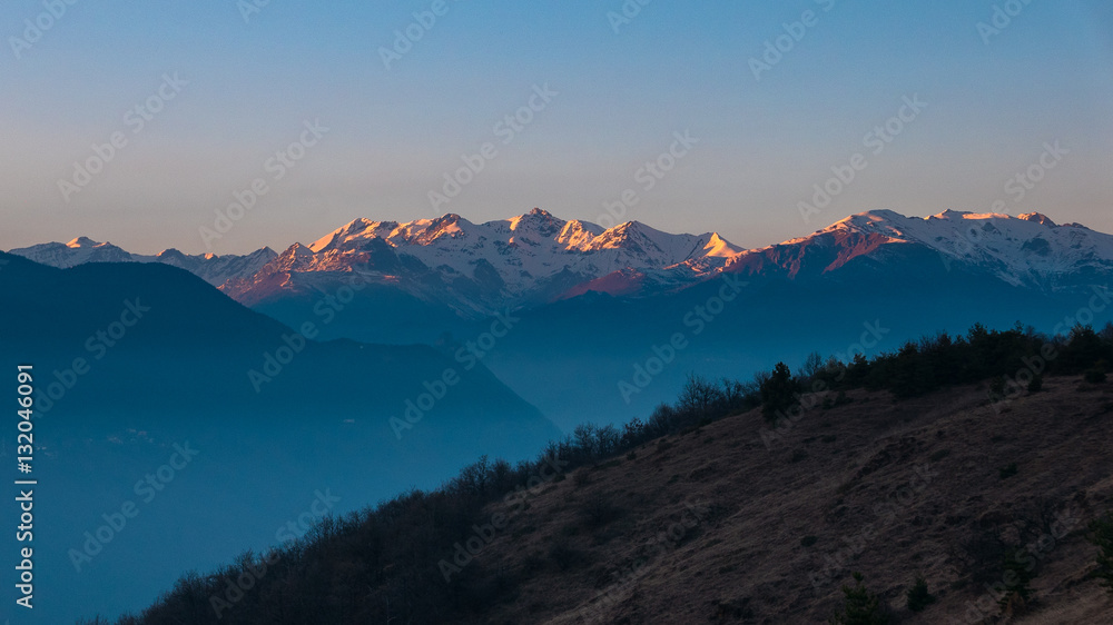 Mountain silhouette and stunning sunlight at dusk, italian Alps