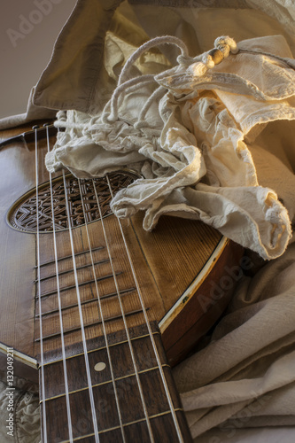 Old Oud Guitar Lute with white rustic baroque shirt with ruffle edging to collars in playing position with perspective view