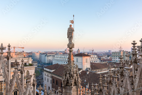 Details of marble spiers and statues of Milan Cathedral, Italy, at sunset. photo