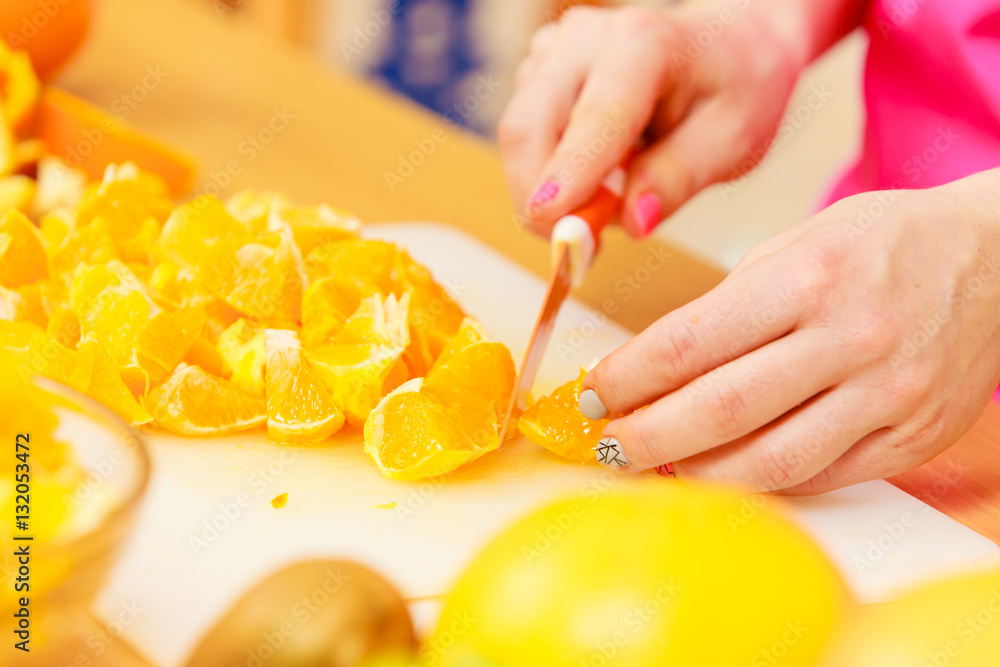 Woman housewife in kitchen cutting orange fruits Woman housewife in kitchen cutting orange fruits