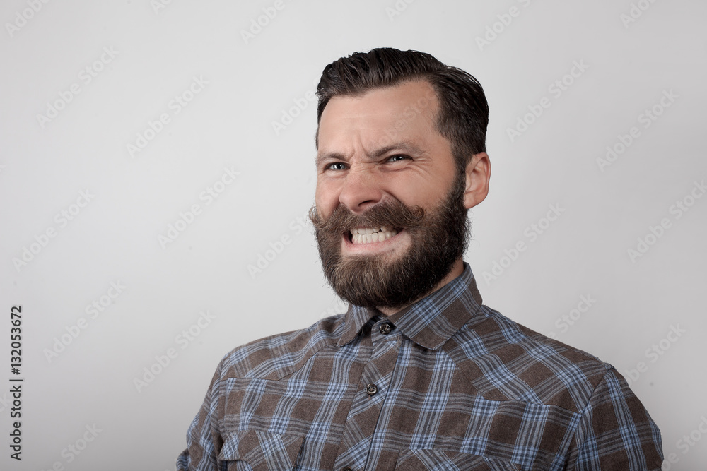 Portrait of an angry bearded young man with a mustache Portrait of an angry bearded young man with a mustache