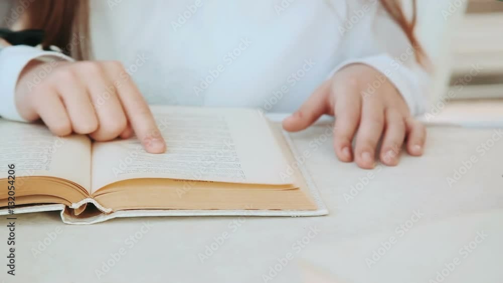 The hand of a little girl leads of the book page. The hand of a little girl leads of the book page.