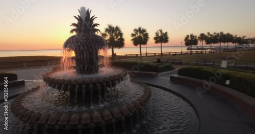 Cinematic aerial perspective of the iconic Pineapple Fountain and a cruise ship docked in Charleston, SC.