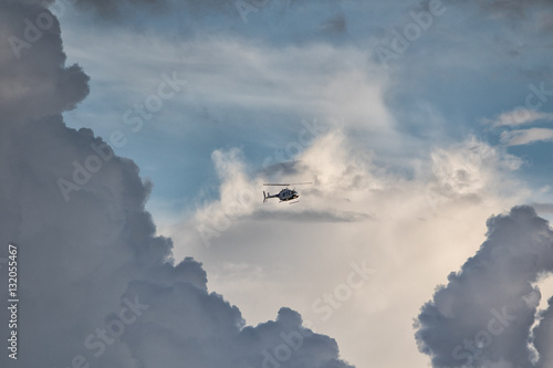 a helicopter flies through the clouds