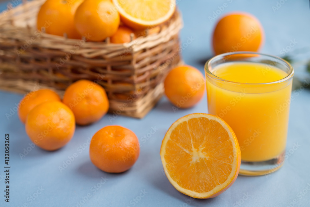 Fresh orange juice in a glass on a background of fruit baskets Fresh orange juice in a glass on a background of fruit baskets