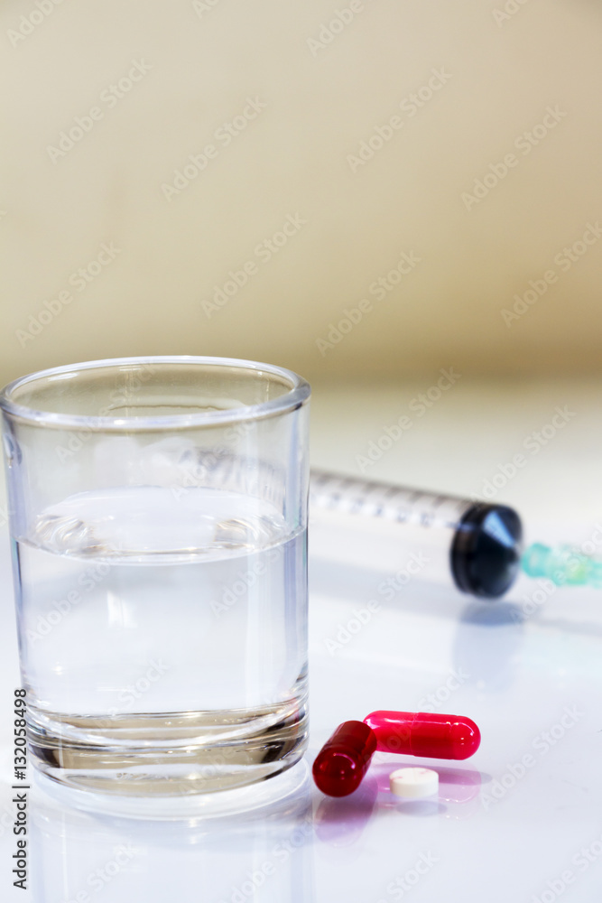 Pills and syringes for treating patients on a white background. Pills and syringes for treating patients on a white background.