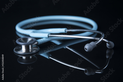 Mint Stethoscope close up view. Blue color Stethoscope with reflection. Stethoscope background. Stethoscope with reflection on glossy black background.
