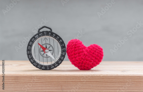 Red heart shape silk with compass on wood table