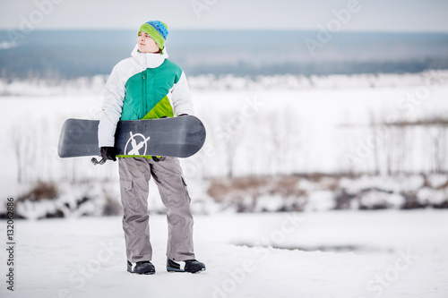 man standng on the snow with snowboard