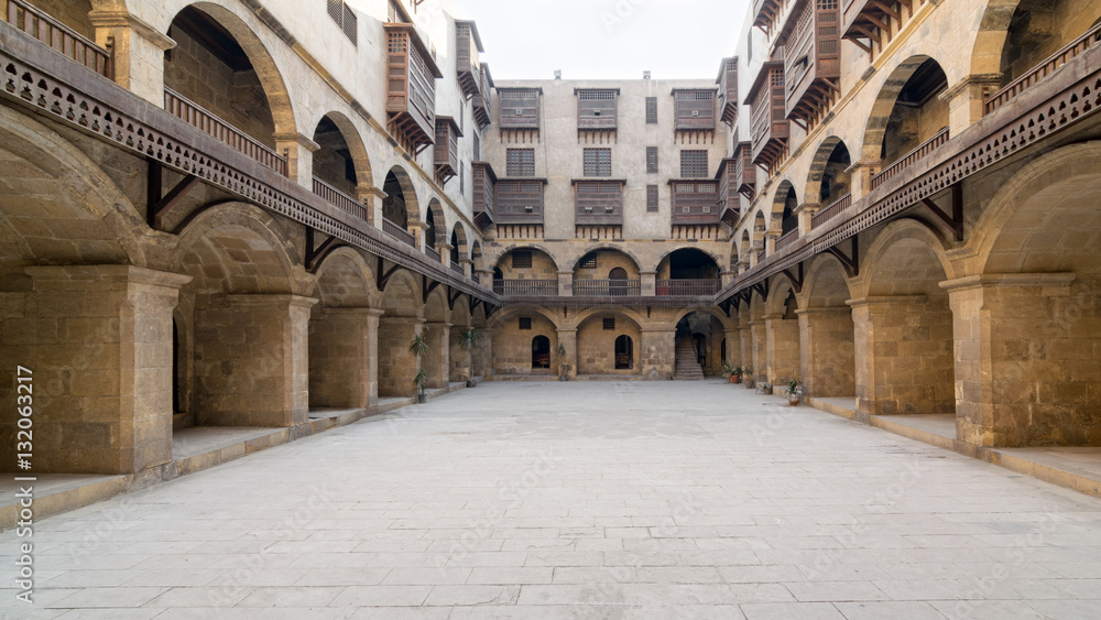 Facade of caravansary (Wikala) of Bazaraa, with vaulted arcades and windows covered by interleaved wooden grids (mashrabiyya), suited in Tombakshia street, Al Gamalia district, Medieval Cairo, Egypt
