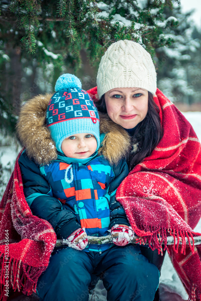 Woman and her son in winter forest