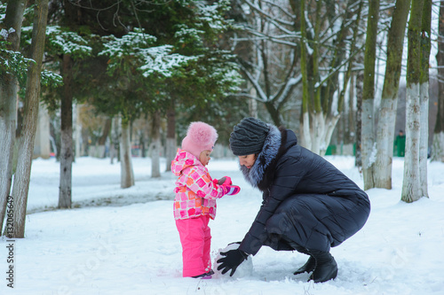 Little girl and her mom playing in the snow