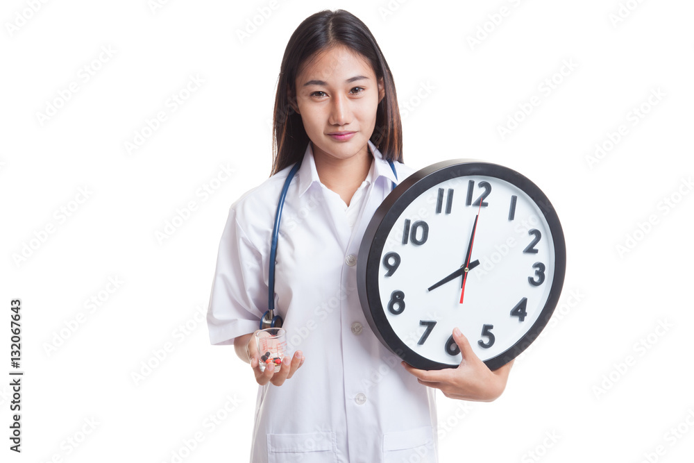 Young Asian female doctor smile with a clock and pills. Young Asian female doctor smile with a clock and pills.