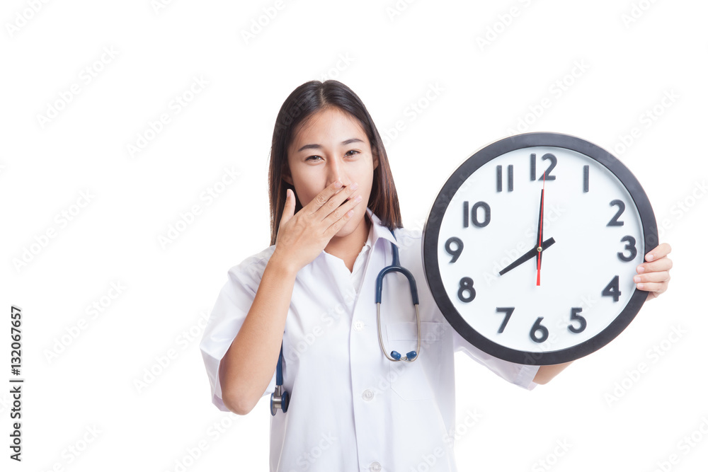 Young Asian female doctor yawn with a clock. Young Asian female doctor yawn with a clock.