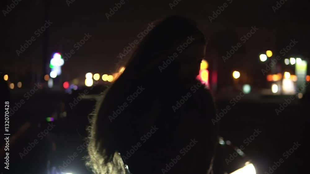 Young girl frustrated waiting for help beside broken car talking on the phone. The car is on emergency gang Young girl frustrated waiting for help beside broken car talking on the phone. The car is on emergency gang