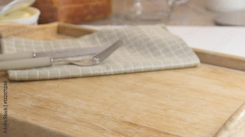 A woman putting a bread, a fork, and a knife on a plate and pouring honey on the bread A woman putting a bread, a fork, and a knife on a plate and pouring honey on the bread