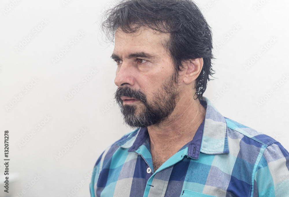 White man, with a black beard careless, short hair somewhat disheveled and blue plaid shirt looking intensely White man, with a black beard careless, short hair somewhat disheveled and blue plaid shirt looking intensely