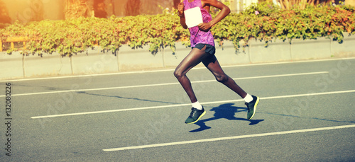 male marathon runner running on city road