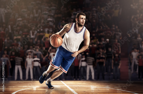 basketball player in light on professional court running with ball © masisyan