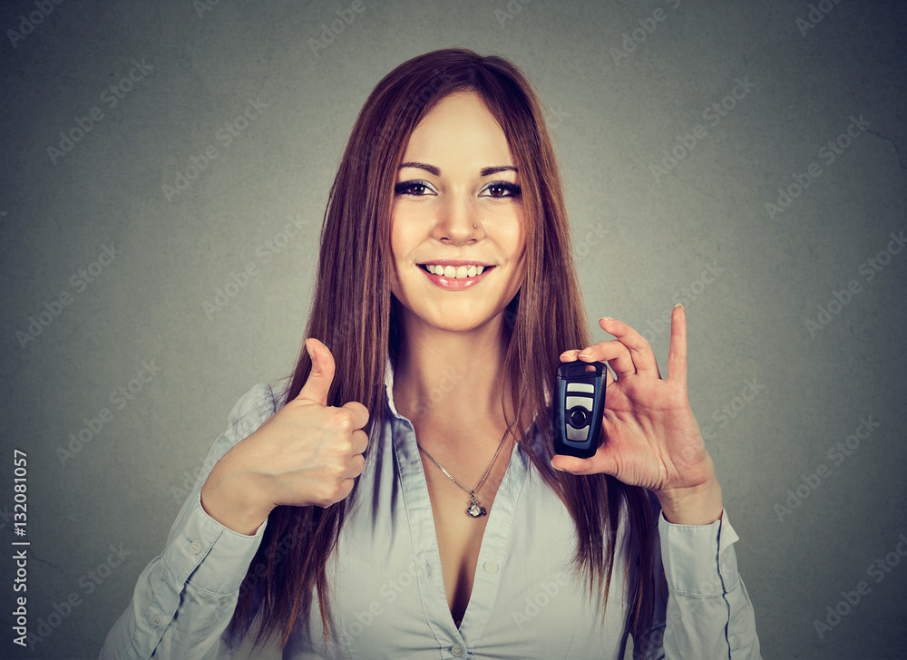 Happy woman showing remote car keys and thumbs up Happy woman showing remote car keys and thumbs up