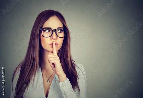 Woman saying hush be quiet with finger on lips gesture photo