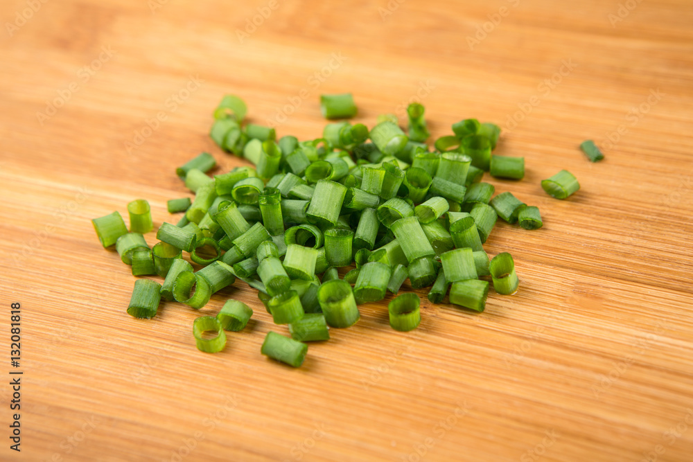 Green onions chopped and stalks isolated on a wood background Green onions chopped and stalks isolated on a wood background