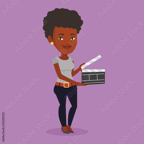 Smiling woman holding an open clapperboard.