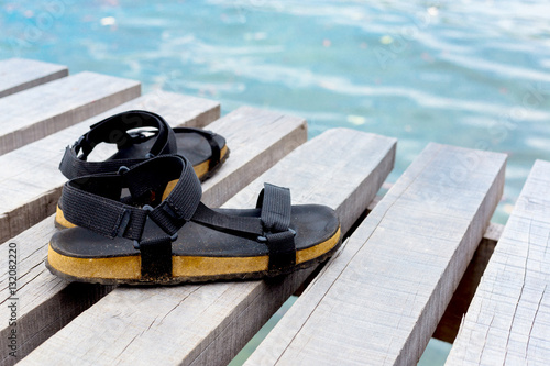Travel concept with footwear over wooden  in front of sea landsc