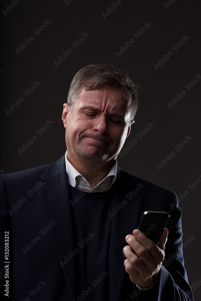 disappointed mature man with mobile phone disappointed mature man with mobile phone