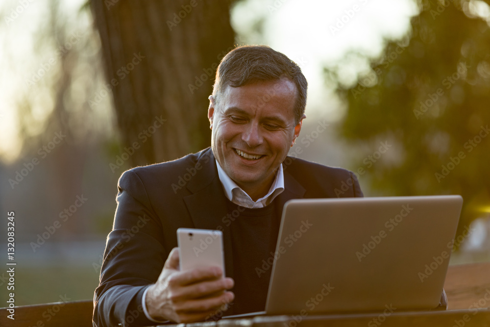 happy businessman receiving a text message happy businessman receiving a text message
