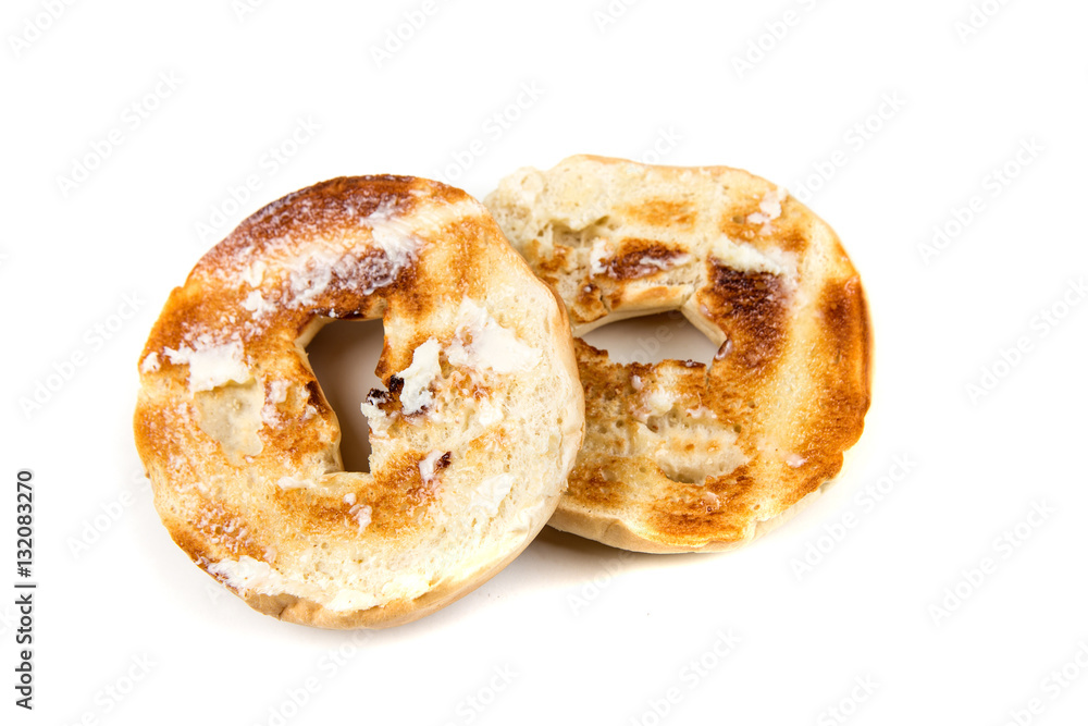 Plain white toasted buttered bagels isolated on a white background
