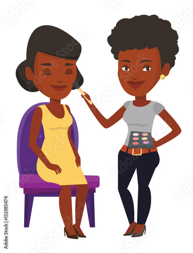 Visagiste doing makeup to young girl.
