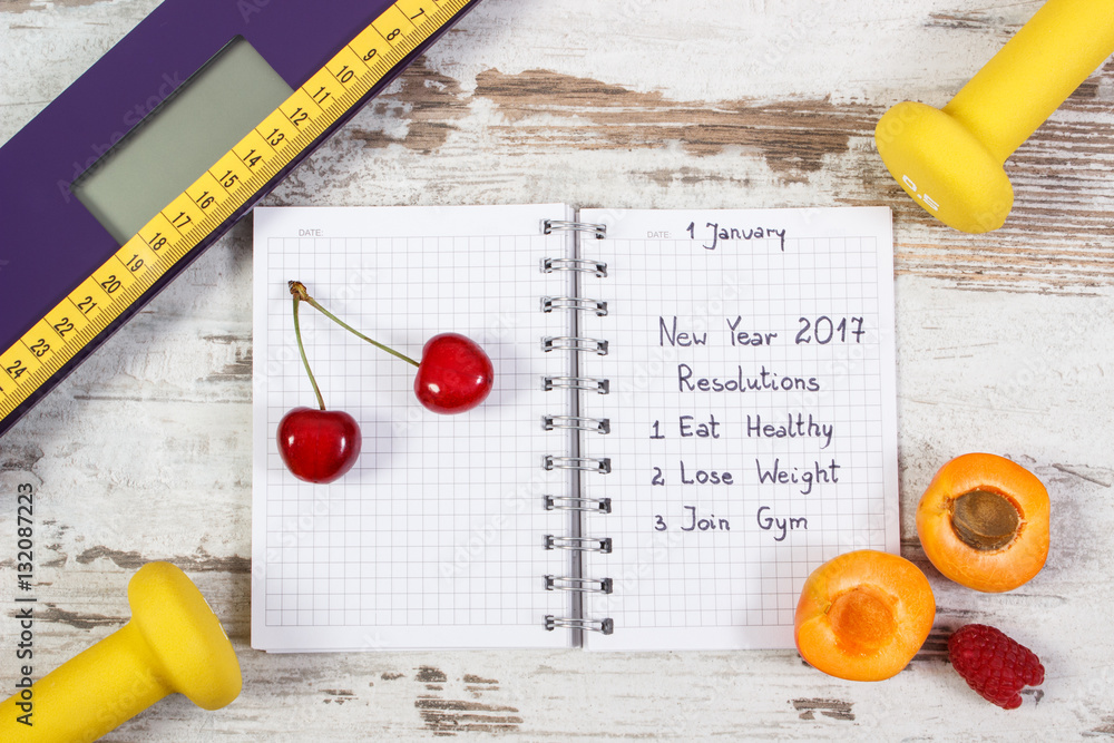 Electronic bathroom scale and new year resolutions written in notebook Electronic bathroom scale and new year resolutions written in notebook