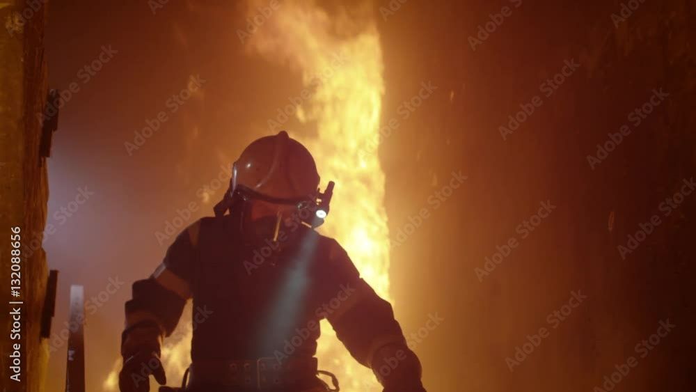 Brave Firefighter With Switched On Flashlight on His Helmet Runs Down the Burning Stairs. Fire is Raging. In Slow Motion. Shot on RED EPIC (uhd). Brave Firefighter With Switched On Flashlight on His Helmet Runs Down the Burning Stairs. Fire is Raging. In Slow Motion. Shot on RED EPIC (uhd).