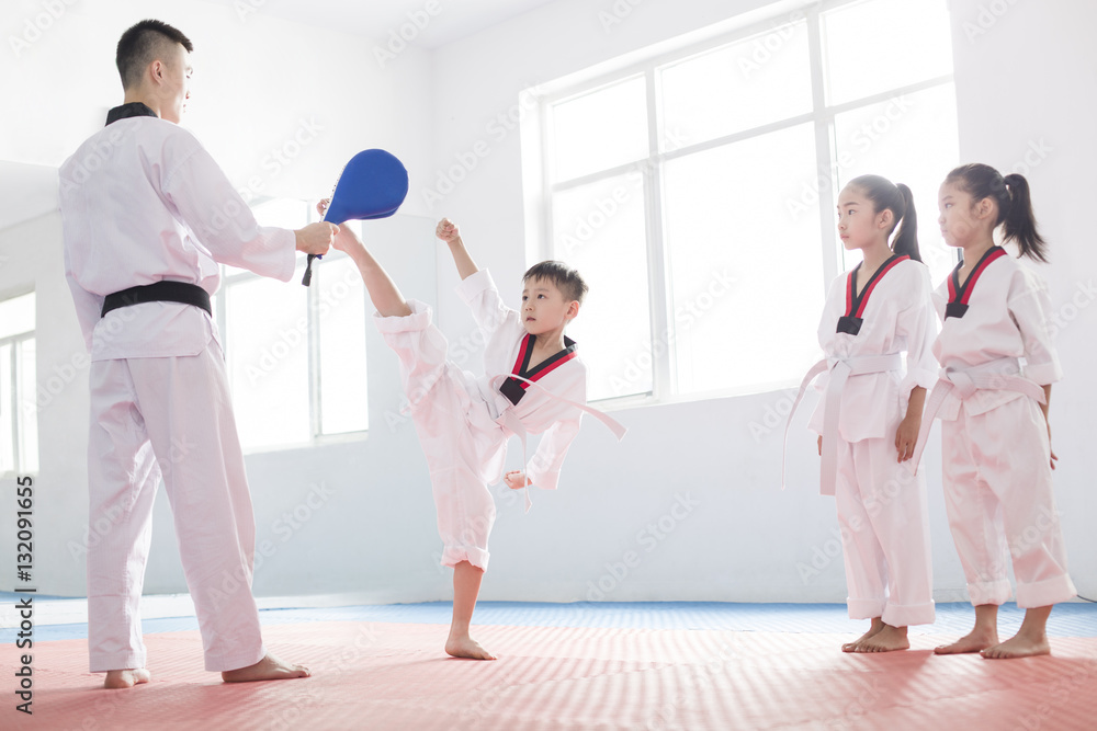 Young instructor teaching taekwondo to children in studio Stock Photo