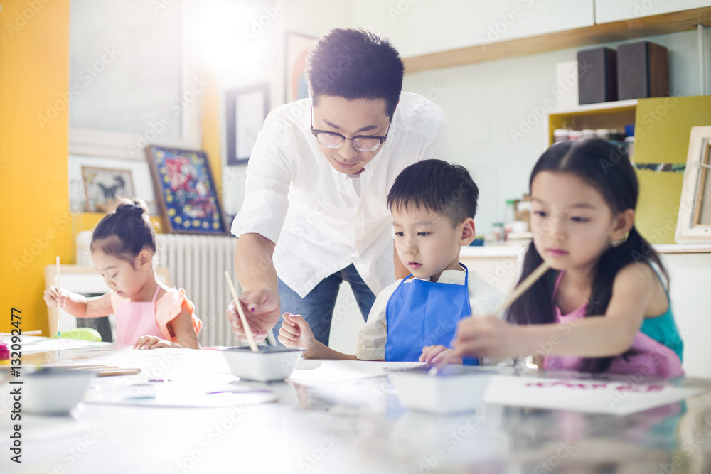 Little children painting in art class with teacher Little children painting in art class with teacher