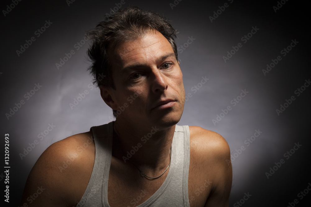 Man low key high-contrast portrait with a serious look on his face. Man low key high-contrast portrait with a serious look on his face.