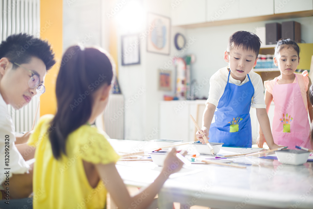 Little children painting in art class with teacher Little children painting in art class with teacher