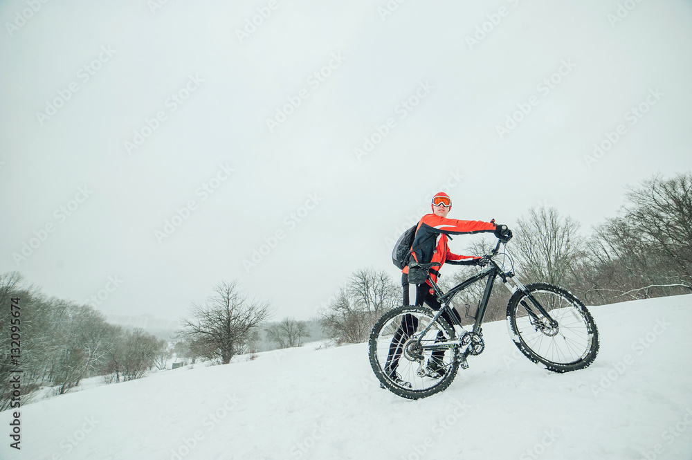 Extreme cyclist rides in the winter snowy forest Extreme cyclist rides in the winter snowy forest