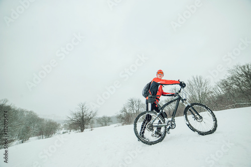 Extreme cyclist rides in the winter snowy forest © Dmitriy Shipilov